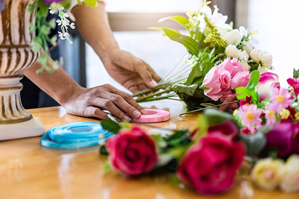 Mains d'une personne formant un bouquet de fleurs artificiels